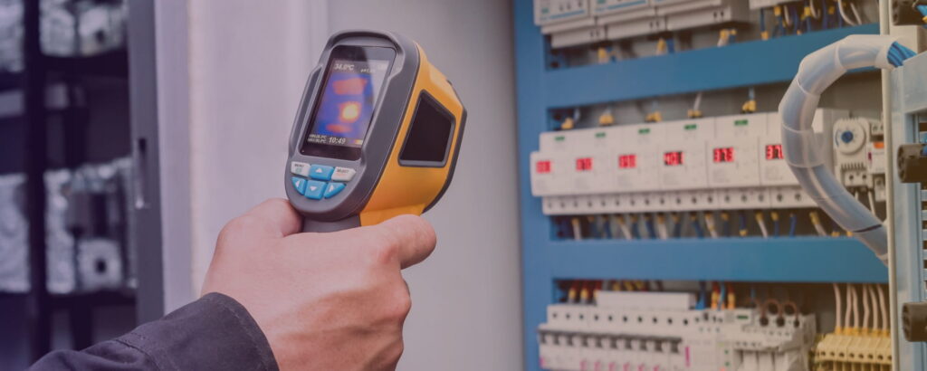 Specjalista przeprowadzający badanie termowizyjne instalacji elektrycznej.